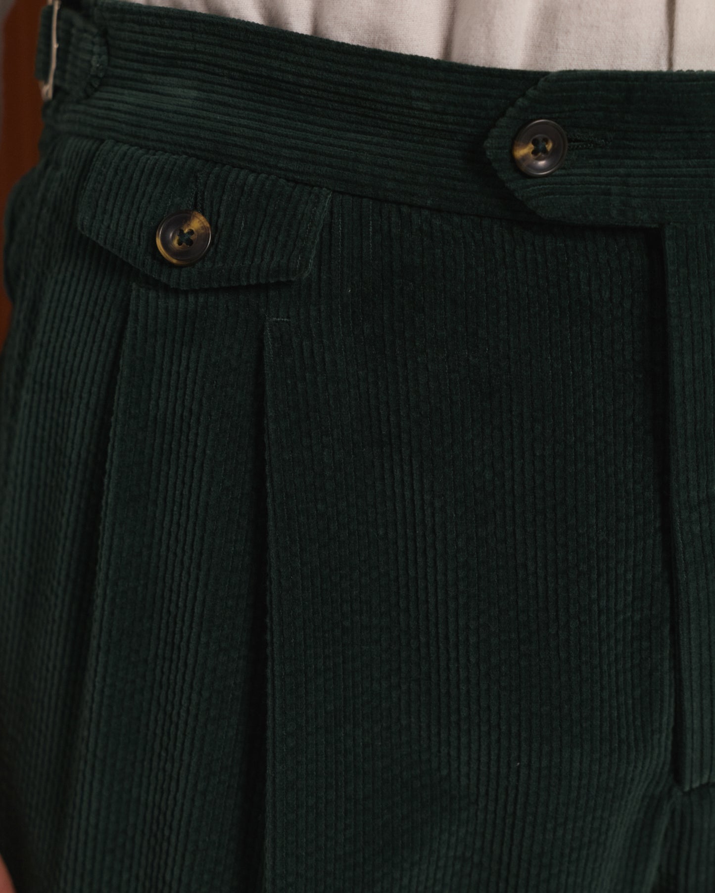 Double-pleated green corduroy trousers